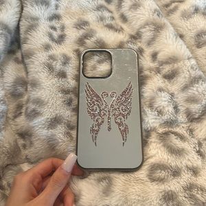 I’m selling an iPhone iPhone 14 pro max with a mirror background and wings.